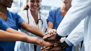 A group of doctors and nurses holding hands.