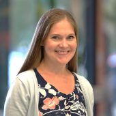 A woman standing in front of a window.