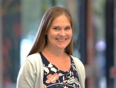 A woman standing in front of a window.
